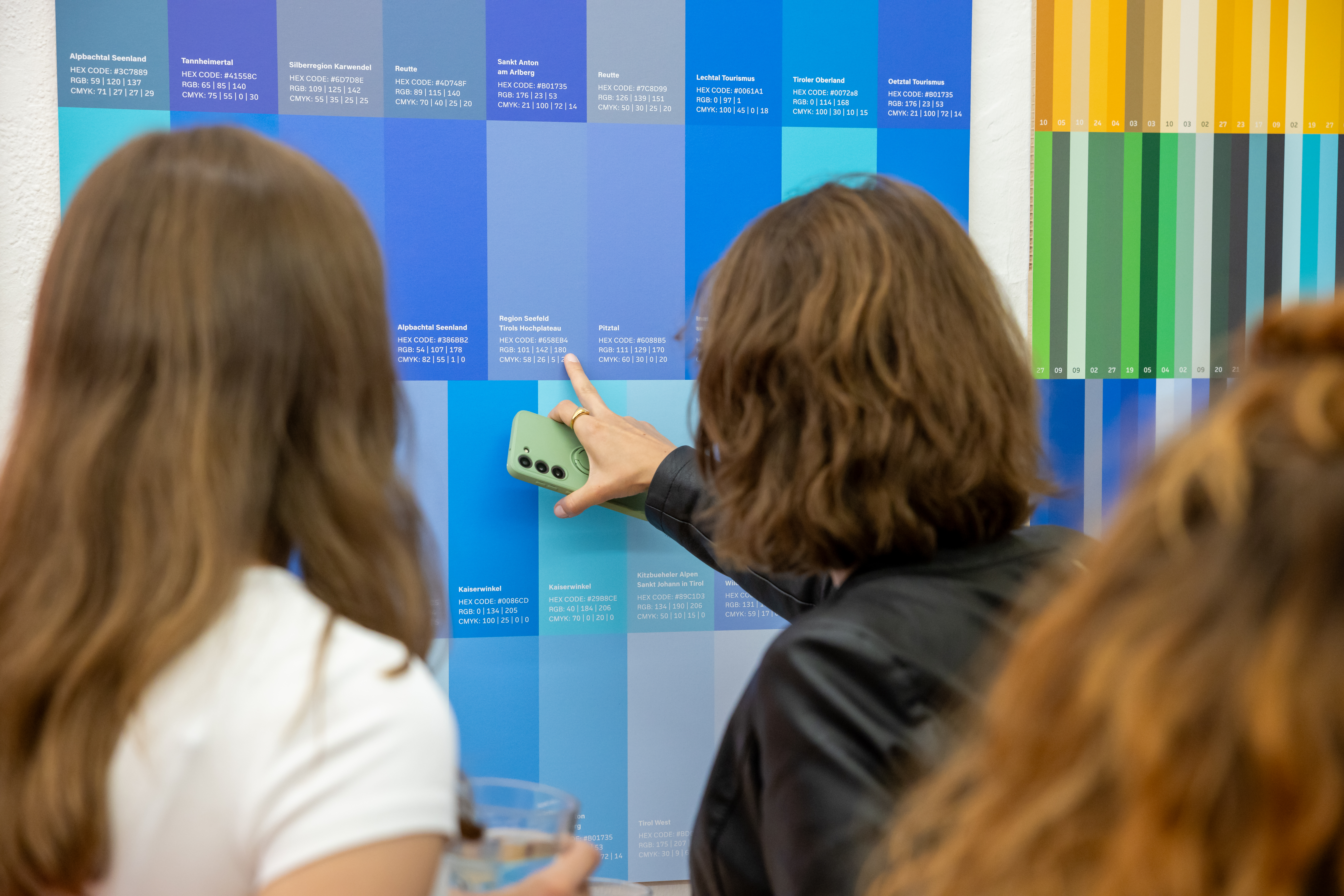Besucherinnen analysieren die Blautöne der Tourismusverbände